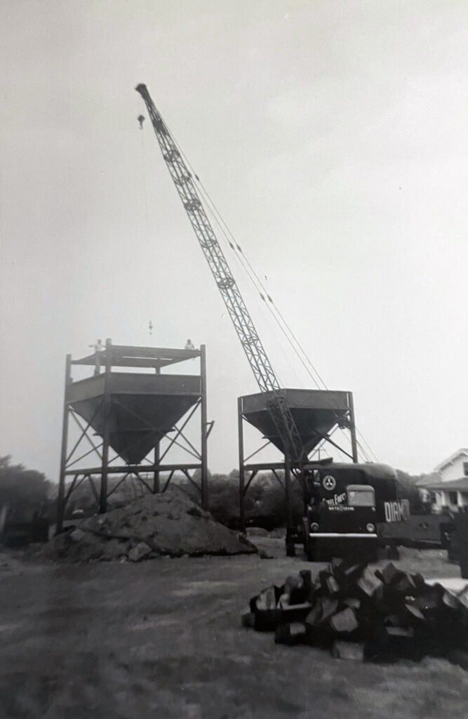 Black and white, dated image of Diamond Steel crane working on jobsite